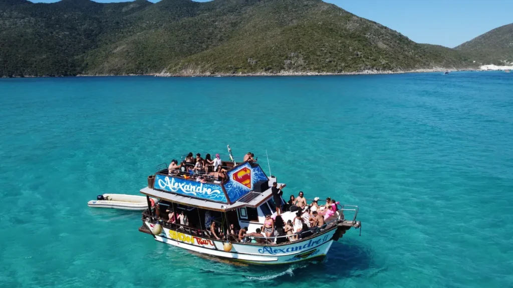 Barco de passeio fundeado no mar turquesa de Arraial do Cabo