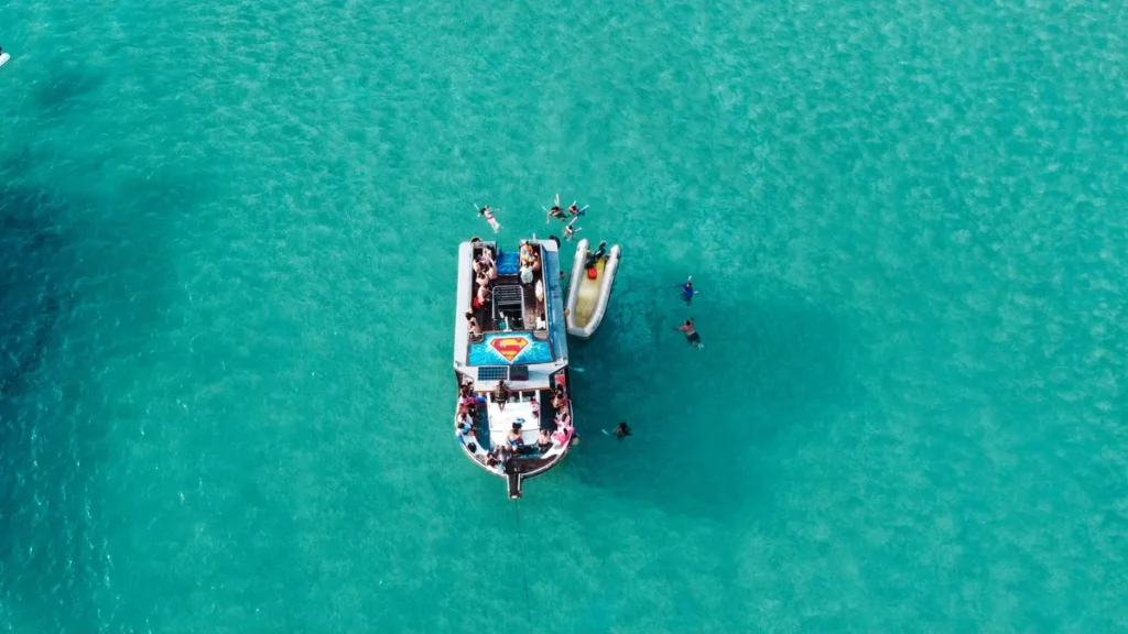 Turistas saltando na água durante o passeio de barco em Arraial do Cabo